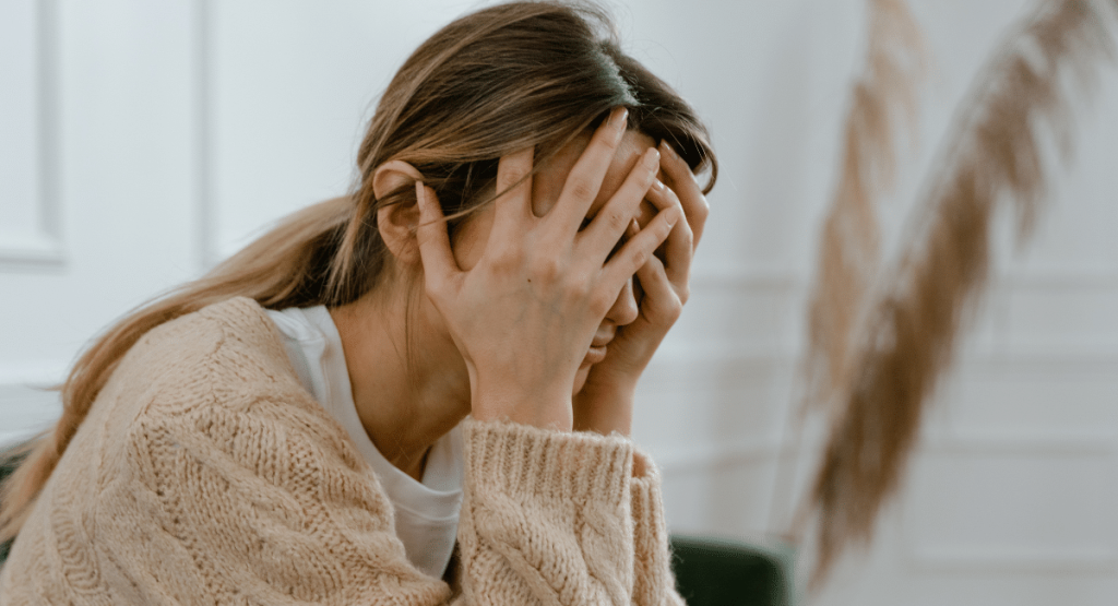 a problematic woman covering her face while considering ketamine for faith crisis in Utah.