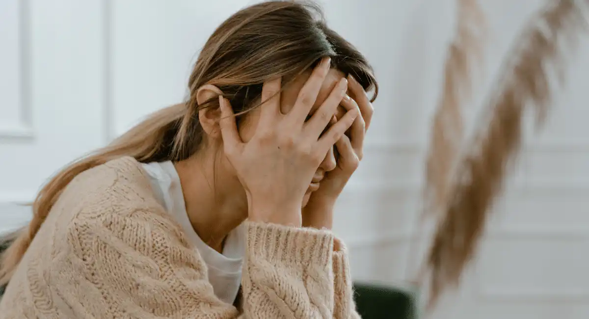 a problematic woman covering her face while considering ketamine for faith crisis in Utah.