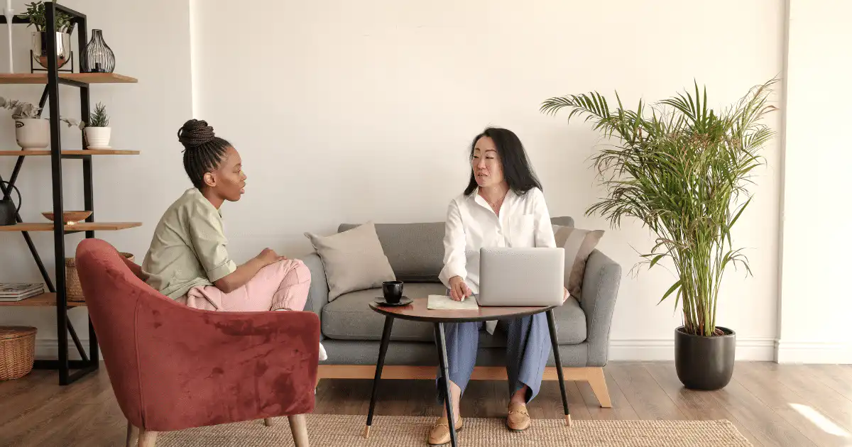 A woman with curly hair counseling or conversing with a woman dressed in white on ketamine vs mushrooms for depression.