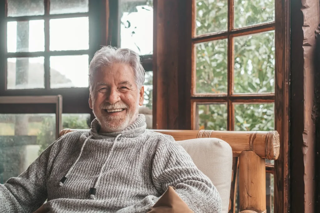 A man smiles in a chair for ketamine for Parkinson’s disease.