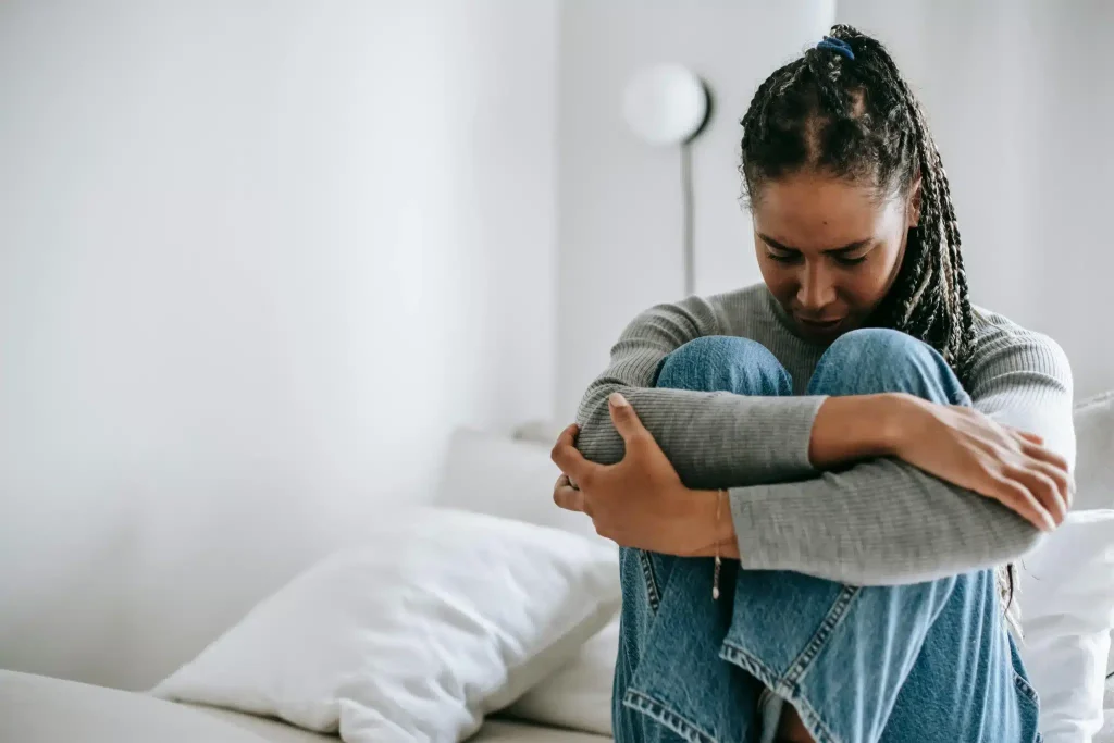 A woman sitting in pain and contemplating ketamine for fibromyalgia treatment at Ketamine Therapy at Therapeutic Alternatives.