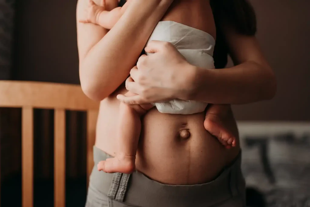 Mother holding newborn close to her chest after ketamine for postpartum depression treatment at Ketamine Therapy at Therapeutic Alternatives.
