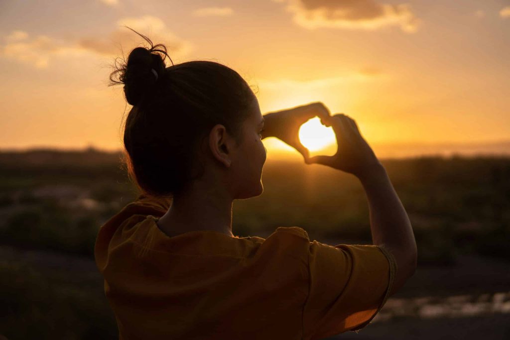 Woman watching the sunset while wondering about the difference of ketamine treatment vs KAP.
